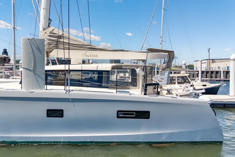 Navitas Yacht Photos Pics 2019 Itacatamarans 14.99 catamaran docked at marina under clear blue sky.