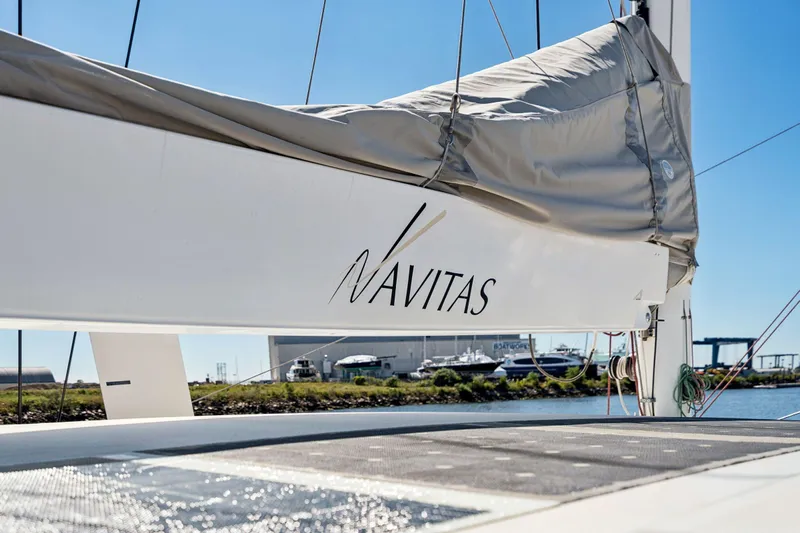 Navitas Yacht Photos Pics 2019 Itacatamarans 14.99 sailboat with "Navitas" branding, docked near a marina.