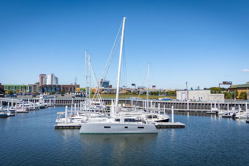 Navitas Yacht Photos Pics 2019 Itacatamarans 14.99 docked in a marina with cityscape background.