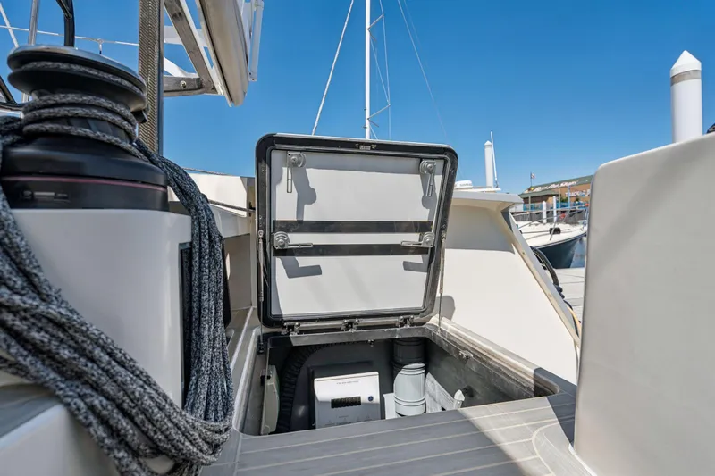 Navitas Yacht Photos Pics 2019 Itacatamarans 14.99 yacht deck with open storage compartment, marina background.