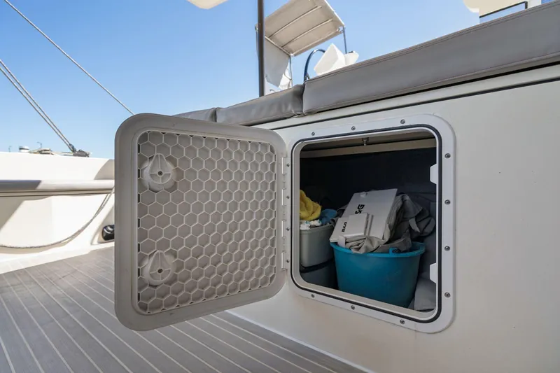 Navitas Yacht Photos Pics Storage compartment on 2019 Itacatamarans 14.99, open with items inside, sunny deck view.
