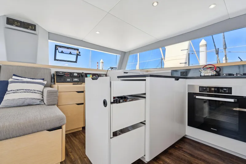 Navitas Yacht Photos Pics Modern interior of 2019 Itacatamarans 14.99 with kitchen and seating area.