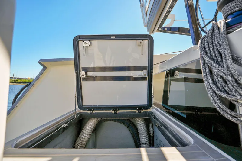 Navitas Yacht Photos Pics Open hatch on 2019 Itacatamarans 14.99 catamaran, showcasing storage compartment and ropes.