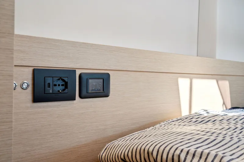 Navitas Yacht Photos Pics Interior of 2019 Itacatamarans 14.99 with power outlet and striped bedding.