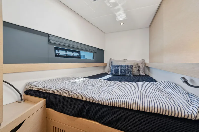 Navitas Yacht Photos Pics Cozy cabin interior of 2019 Itacatamarans 14.99 with modern bedding and window view.