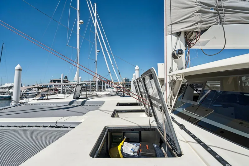 Navitas Yacht Photos Pics 2019 Itacatamarans 14.99 catamaran deck with open hatches in marina setting.