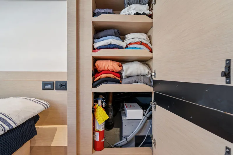 Navitas Yacht Photos Pics Cabin storage on 2019 Itacatamarans 14.99 with clothes and fire extinguisher.