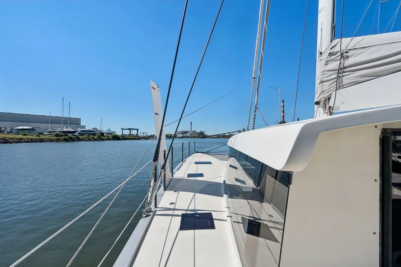 Navitas Yacht Photos Pics 2019 Itacatamarans 14.99 sailing on a calm river under clear blue skies.