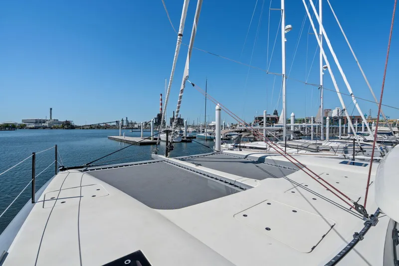 Navitas Yacht Photos Pics 2019 Itacatamarans 14.99 catamaran docked at a marina under clear blue skies.