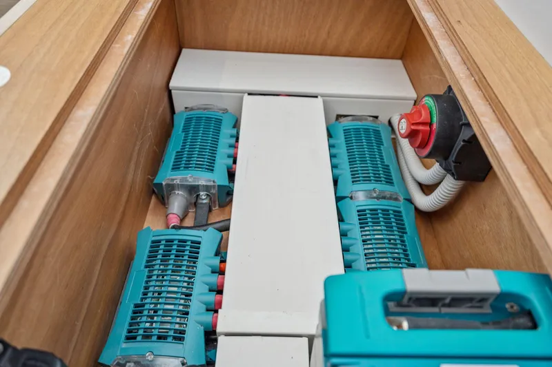 Navitas Yacht Photos Pics Electrical components inside a 2019 Itacatamarans 14.99, featuring teal devices and a red switch.