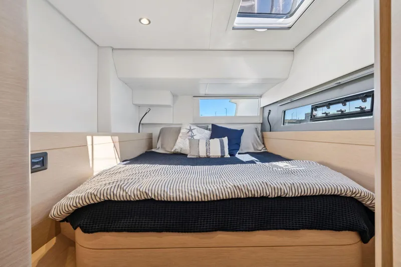 Navitas Yacht Photos Pics Luxurious cabin interior of 2019 Itacatamarans 14.99 with cozy bedding and modern design.