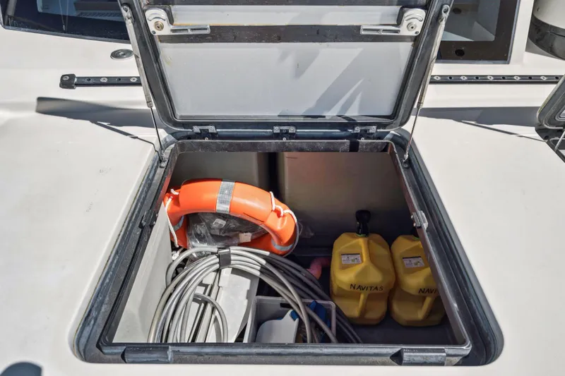 Navitas Yacht Photos Pics Open storage compartment on 2019 Itacatamarans 14.99 with life preserver and yellow containers.