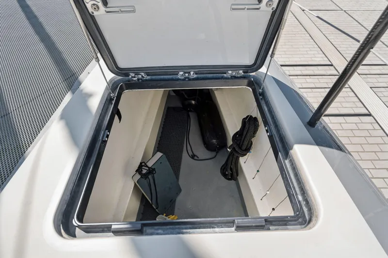 Navitas Yacht Photos Pics Open storage compartment on 2019 Itacatamarans 14.99 catamaran deck, showing ropes and equipment.