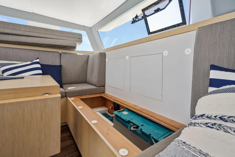 Navitas Yacht Photos Pics Interior of 2019 Itacatamarans 14.99, featuring storage under seating with nautical decor.