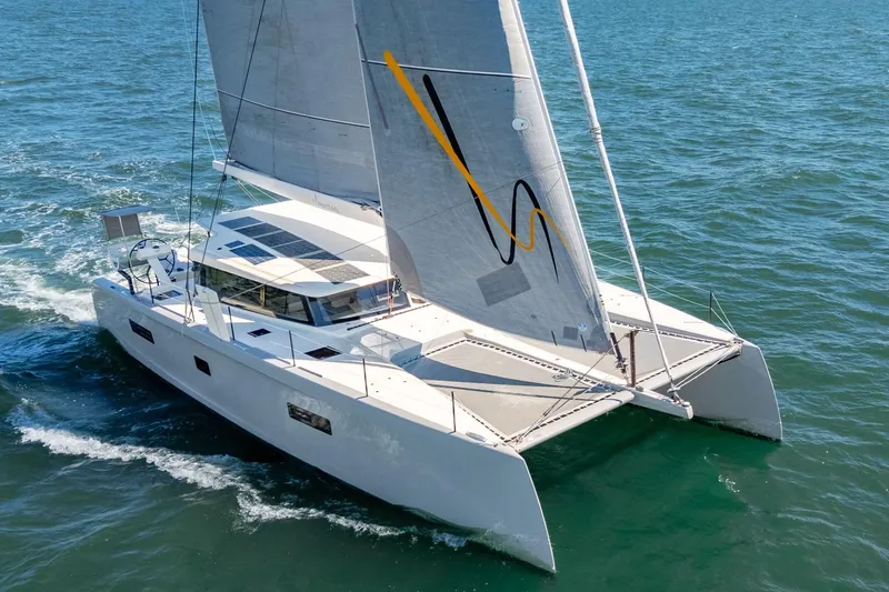 Navitas Yacht Photos Pics 2019 Itacatamarans 14.99 sailing on open water, showcasing sleek design and solar panels.