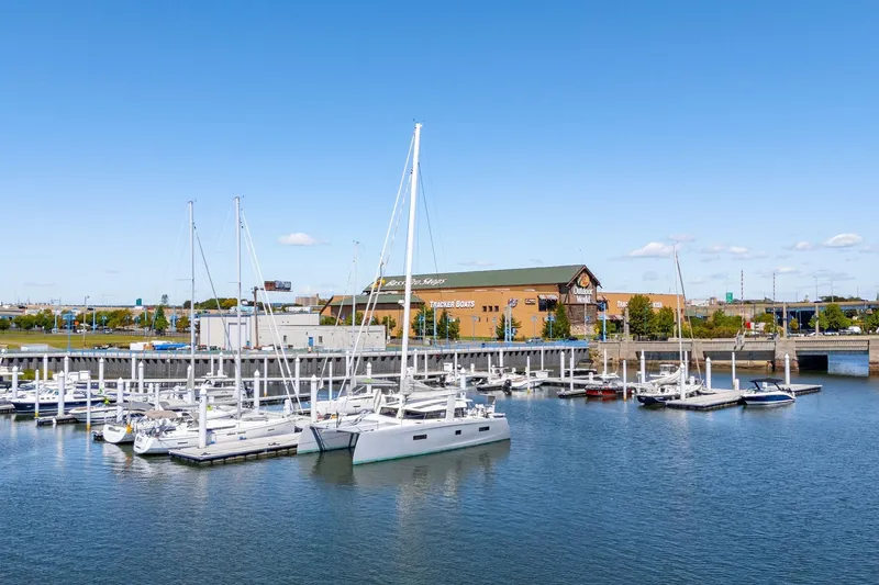 Navitas Yacht Photos Pics Marina with 2019 Itacatamarans 14.99 catamaran docked, clear blue sky, and waterfront buildings.