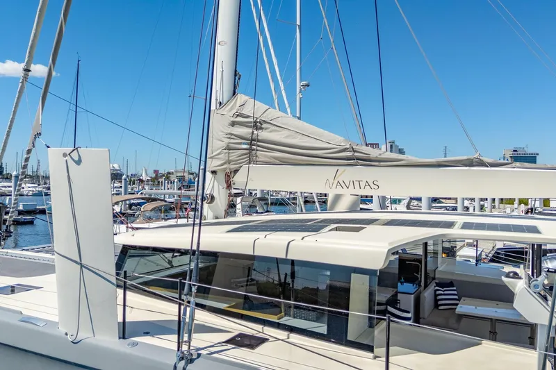Navitas Yacht Photos Pics 2019 Itacatamarans 14.99 catamaran docked at marina, featuring sleek design and spacious deck.