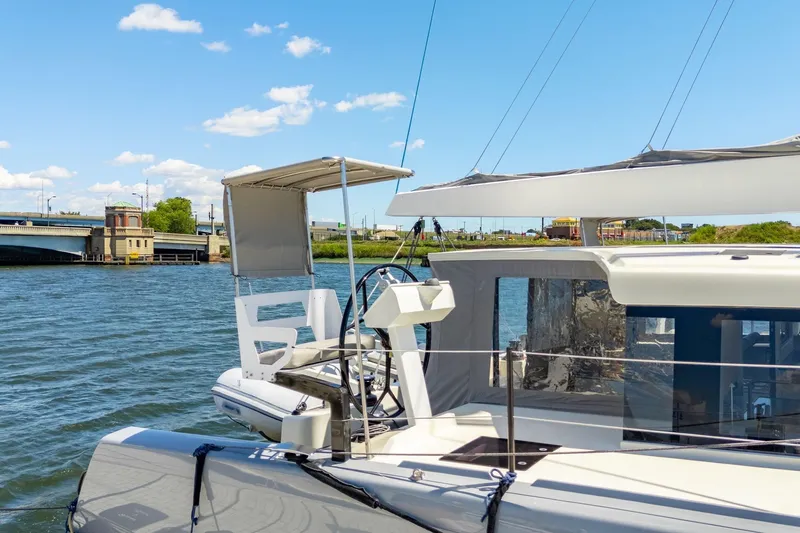 Navitas Yacht Photos Pics 2019 Itacatamarans 14.99 catamaran docked by a scenic waterfront under a clear blue sky.