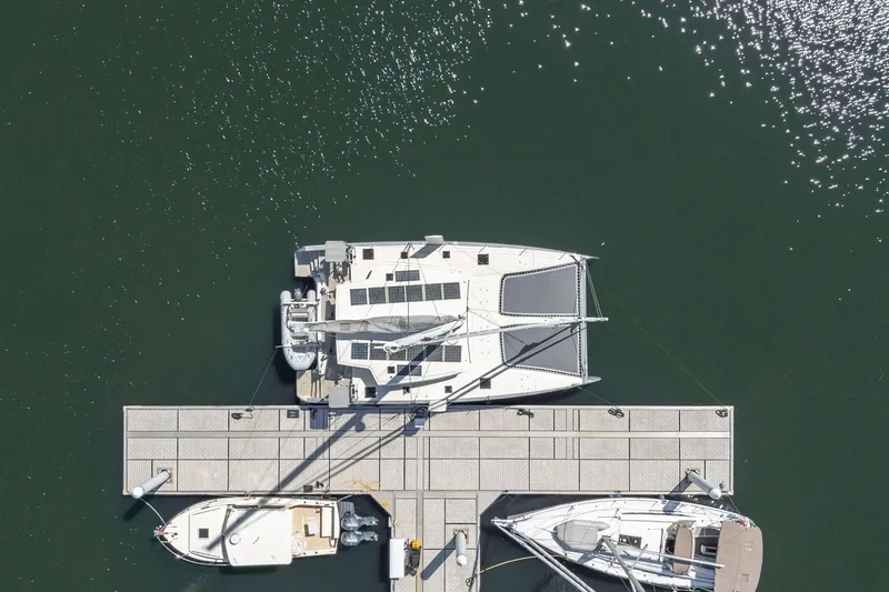 Navitas Yacht Photos Pics Overhead view of 2019 Itacatamarans 14.99 docked at marina, surrounded by water.