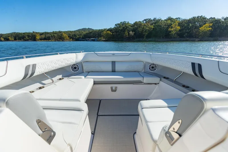 The Big Dill Yacht Photos Pics Luxurious 2023 Regal LS36 boat interior with white seating, on a serene lake.
