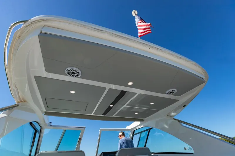 The Big Dill Yacht Photos Pics 2023 Regal LS36 boat with American flag, sleek design, and modern features under clear blue sky.