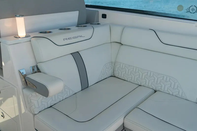The Big Dill Yacht Photos Pics Luxurious seating on 2023 Regal LS36 boat with elegant white upholstery and cup holders.