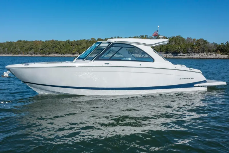 The Big Dill Yacht Photos Pics 2023 Regal LS36 boat cruising on a serene lake with clear blue skies.