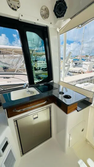  Yacht Photos Pics 2025 Boston Whaler 365 Conquest interior with kitchenette, sink, and marina view.