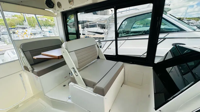  Yacht Photos Pics Interior of 2025 Boston Whaler 365 Conquest, featuring seating and table, docked at marina.