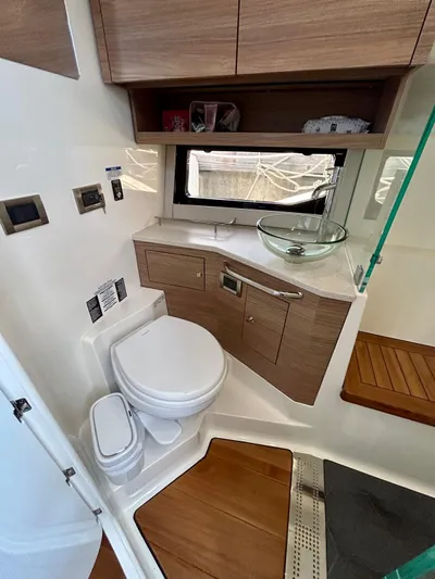  Yacht Photos Pics 2025 Boston Whaler 365 Conquest bathroom with modern fixtures and wooden cabinetry.