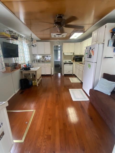 Spacious 1985 Arc houseboat interior with wooden flooring and modern kitchen amenities.