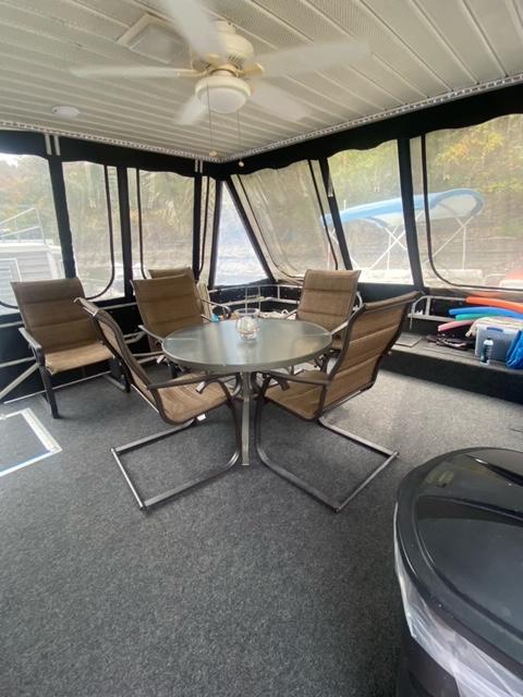 Enclosed deck of 1985 Arc houseboat with table and chairs.