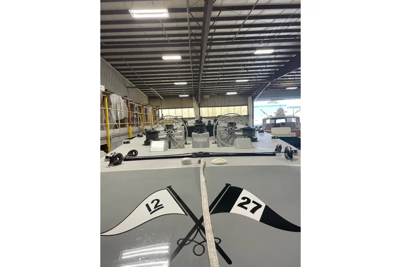 Enterprise Yacht Photos Pics 1997 Sparkman & Stephens 12M yacht in a warehouse, showcasing deck details and equipment.