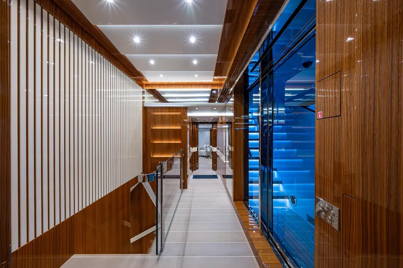 Goldeneye Yacht Photos Pics Luxurious interior of 2020 Mangusta 54 Gransport yacht with modern wood paneling and ambient lighting.