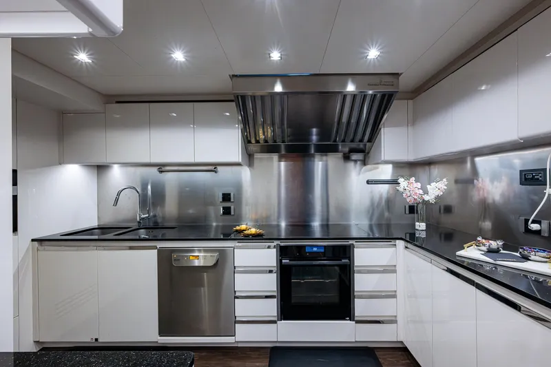 Goldeneye Yacht Photos Pics Modern kitchen interior on 2020 Mangusta 54 Gransport yacht, featuring sleek cabinetry and stainless steel appliances.