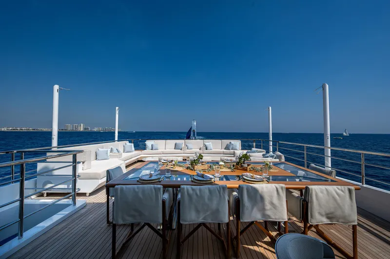 Goldeneye Yacht Photos Pics Luxurious deck of 2020 Mangusta 54 Gransport yacht with ocean view and elegant dining setup.