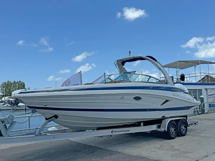  Yacht Photos Pics 2024 Crownline 290 XSS boat on trailer, dockside, under clear blue sky.