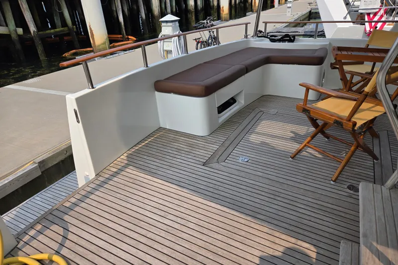 Wa Yacht Photos Pics Deck seating area on a 2012 Beneteau Swift Trawler 52, featuring wooden chairs and flooring.