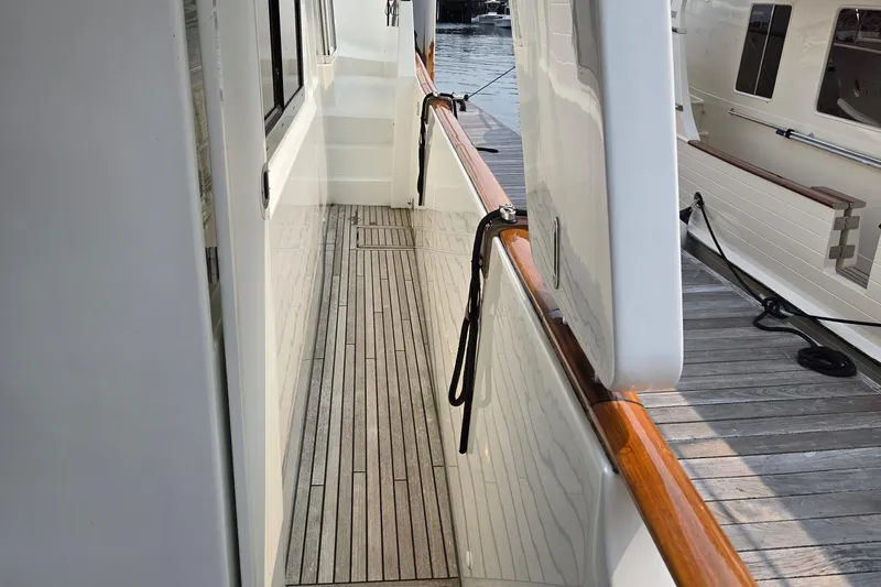 Wa Yacht Photos Pics Side deck of 2012 Beneteau Swift Trawler 52 with wooden flooring and dock view.