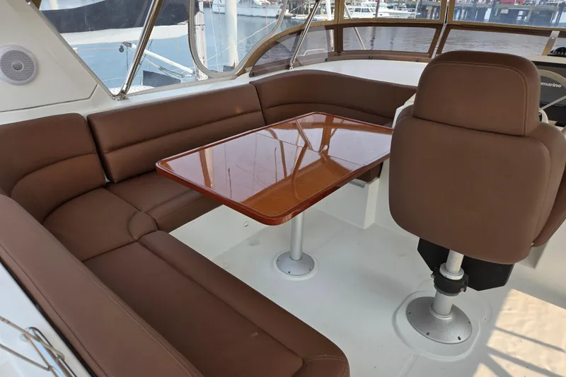 Wa Yacht Photos Pics Interior of 2012 Beneteau Swift Trawler 52 with brown seating and wooden table.