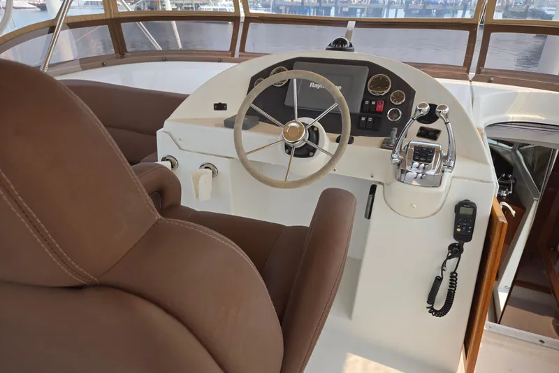 Wa Yacht Photos Pics Helm station of 2012 Beneteau Swift Trawler 52 with brown seating and navigation controls.