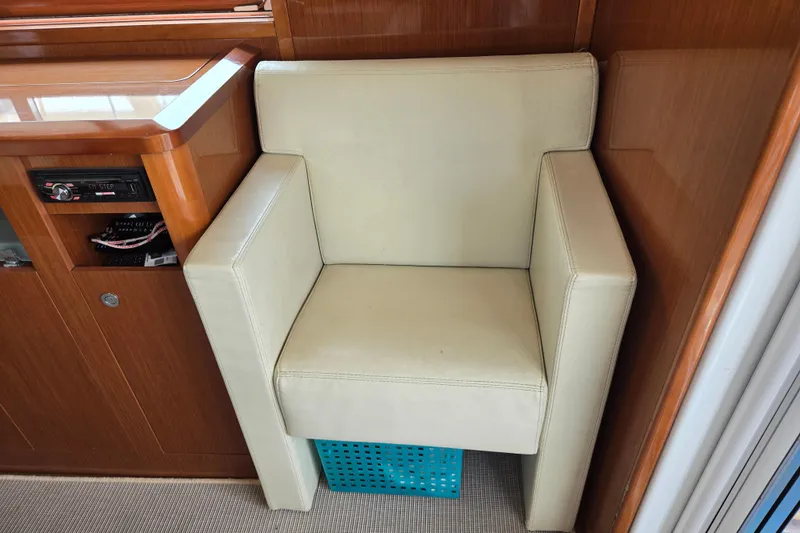 Wa Yacht Photos Pics Cream chair in 2012 Beneteau Swift Trawler 52 interior, next to wooden cabinetry.