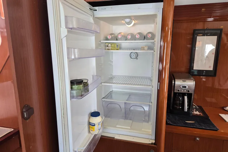Wa Yacht Photos Pics Open refrigerator in 2012 Beneteau Swift Trawler 52 galley, with condiments and coffee maker nearby.