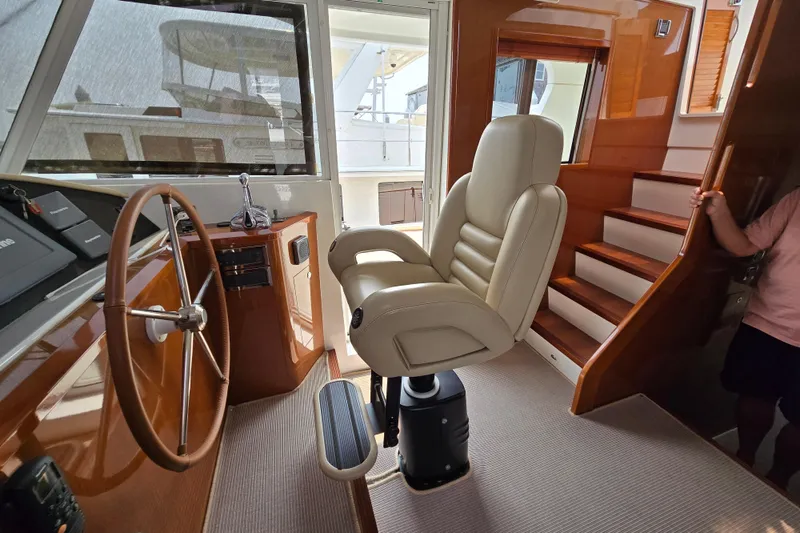 Wa Yacht Photos Pics 2012 Beneteau Swift Trawler 52 helm station with leather captain's chair and wooden steering wheel.