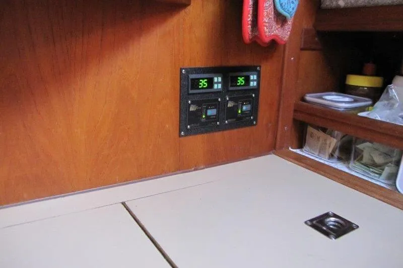 Bella Yacht Photos Pics Control panel inside 1983 Nauticat 43 sailboat, featuring digital displays and wooden interior.