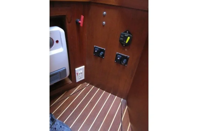 Bella Yacht Photos Pics 1983 Nauticat 43 interior control panel with wooden finish and electrical switches.