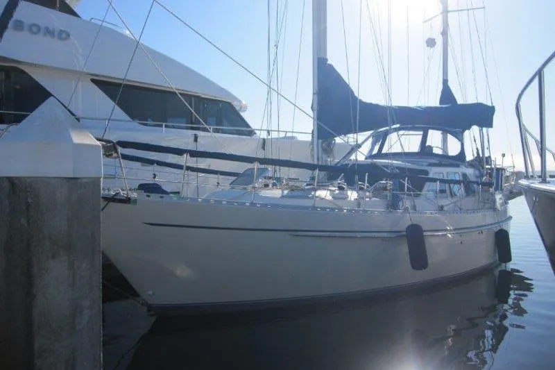 Bella Yacht Photos Pics 1983 Nauticat 43 sailboat docked in marina, side view with blue canopy.