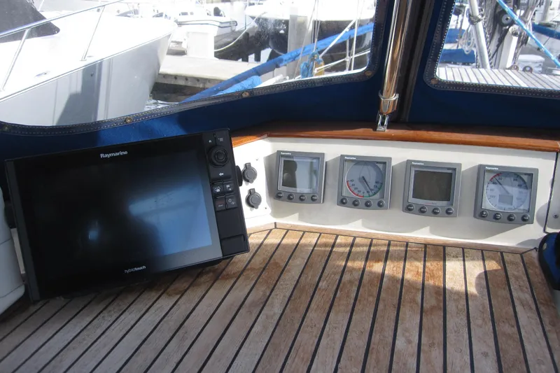 Bella Yacht Photos Pics Control panel of 1983 Nauticat 43 sailboat with navigation instruments and Raymarine display.