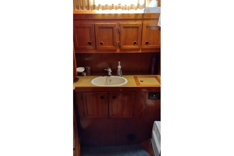 Bella Yacht Photos Pics 1983 Nauticat 43 yacht interior with wooden cabinets and sink.