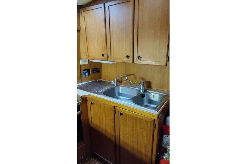 Bella Yacht Photos Pics 1983 Nauticat 43 yacht kitchen with wooden cabinets and stainless steel sink.